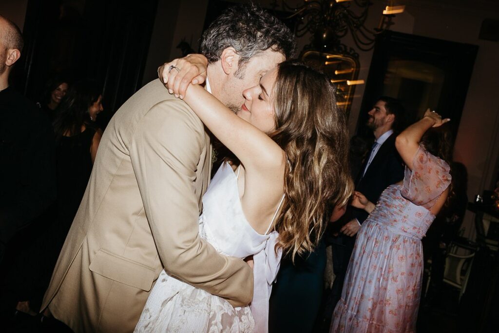 The bride and groom dancing together surrounded by their guests