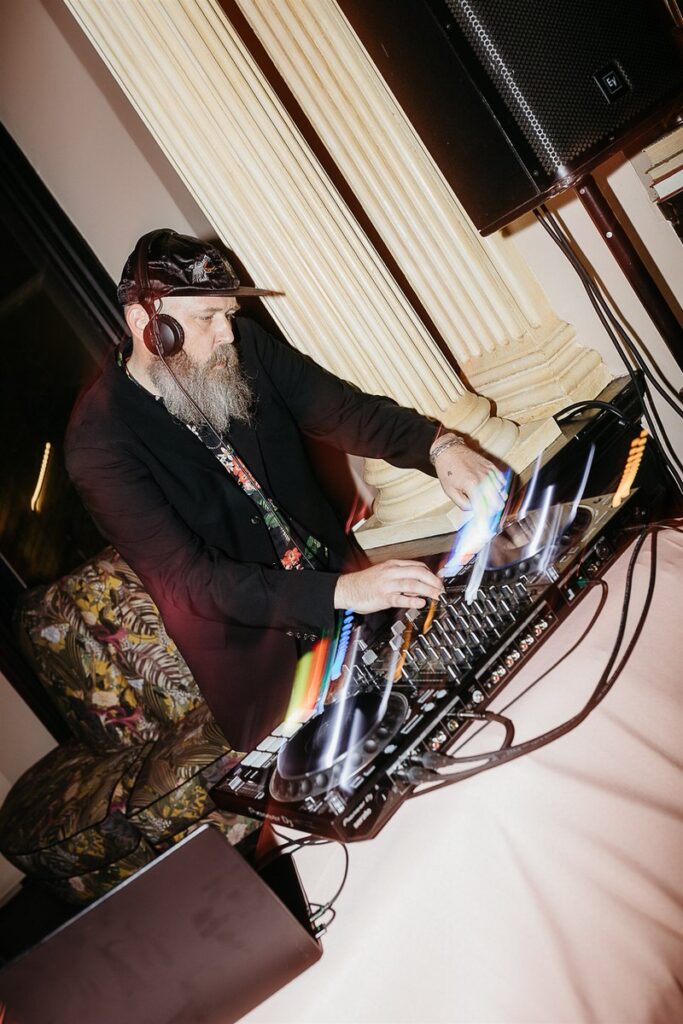 The DJ mixes music at the reception, with colorful light streaks 