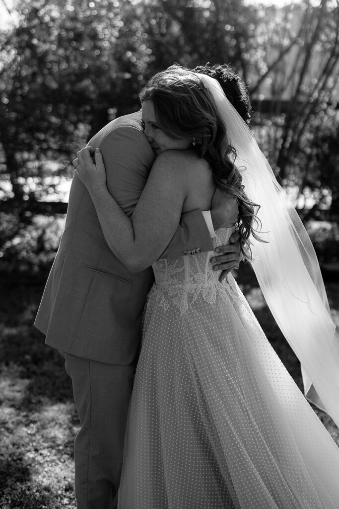 Black and white photo of a couple hugging on their wedding day