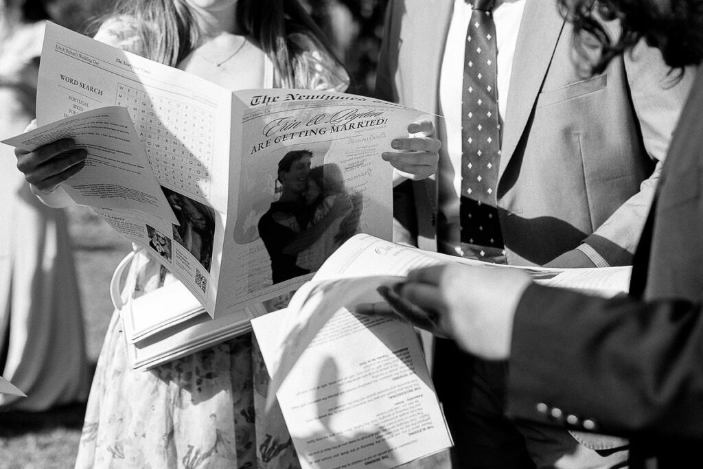 Guests reading a newspaper style wedding pamphlet 
