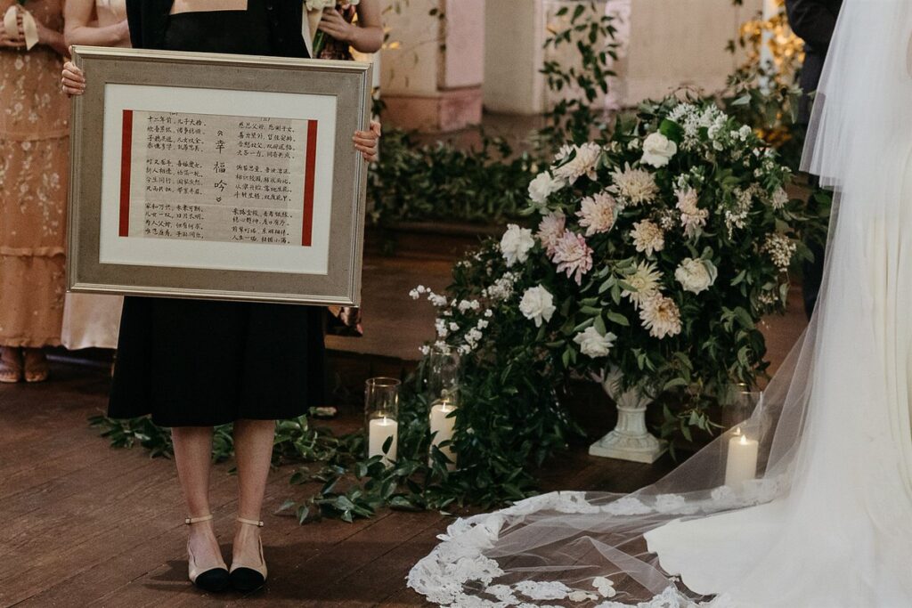 A person holding up a frame with foreign script on the image 