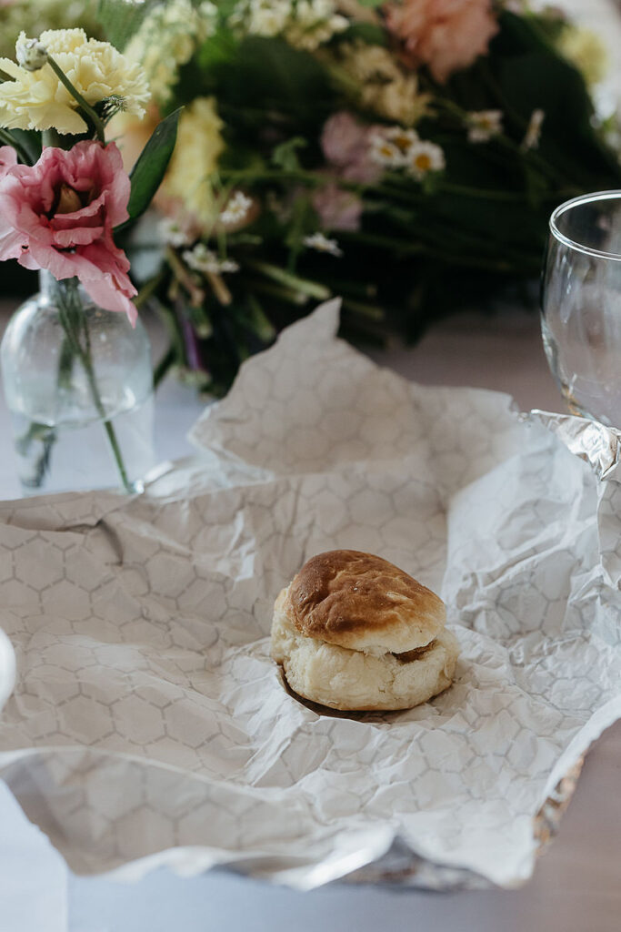 Single biscuit on crumpled paper with flowers in the background.
