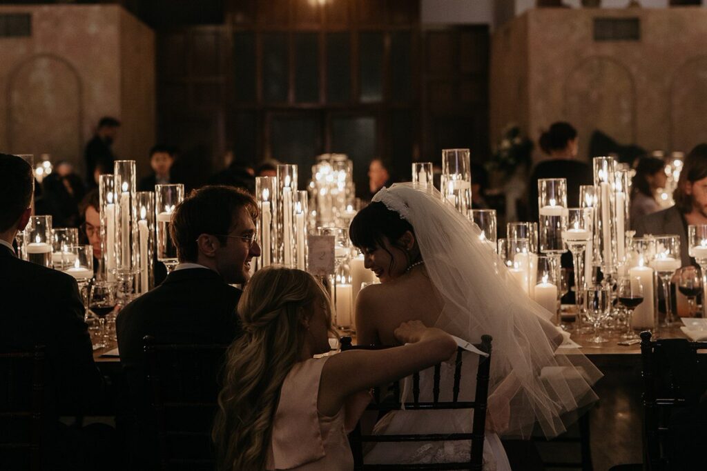 A person adjusting the bride's dress as she is sitting down 