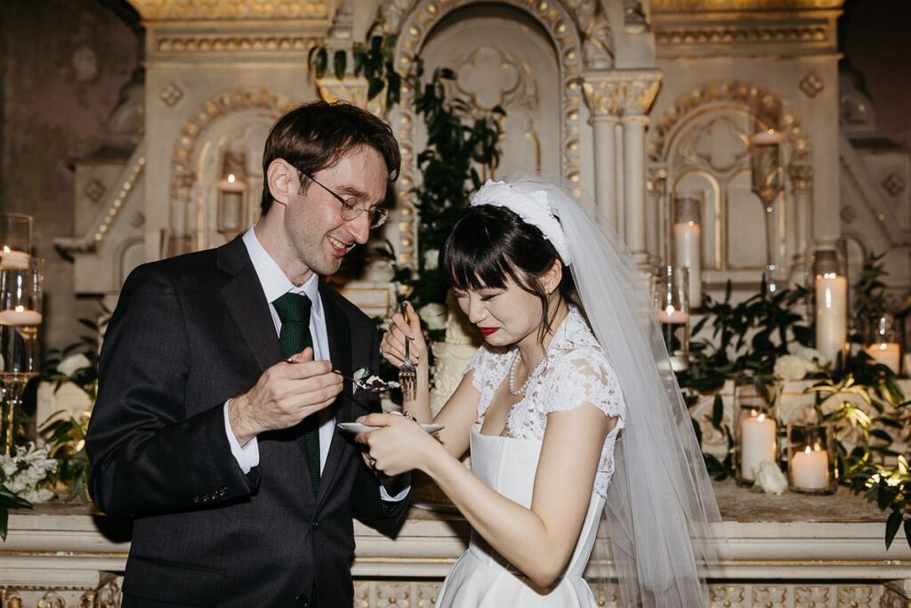 A bride and groom eating cake together 