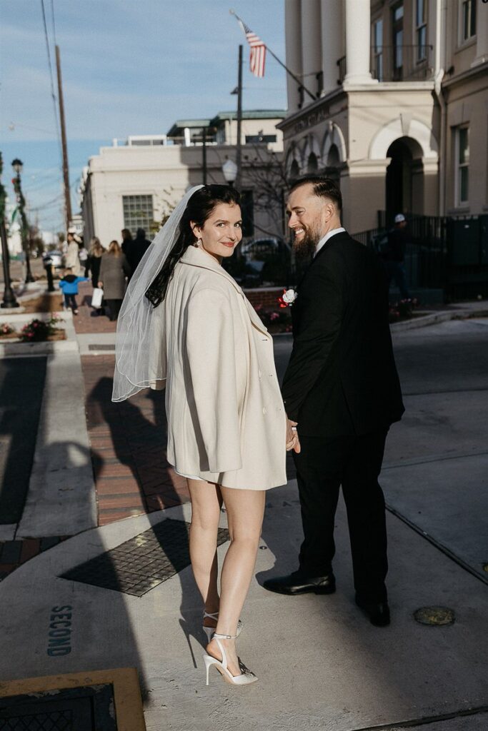 A wedding couple walking down the street and smiling 