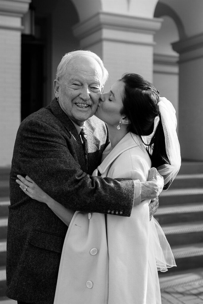 A bride kissing an older relative's cheek 
