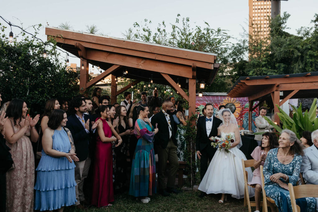 A person walking down the aisle with their father during their wedding ceremony