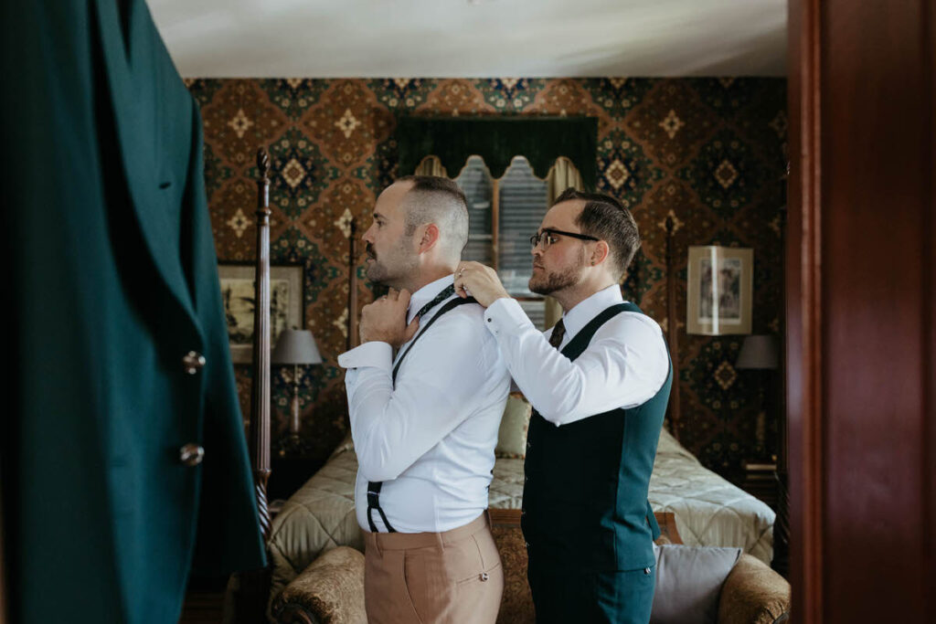 A person helping another person put on a tie