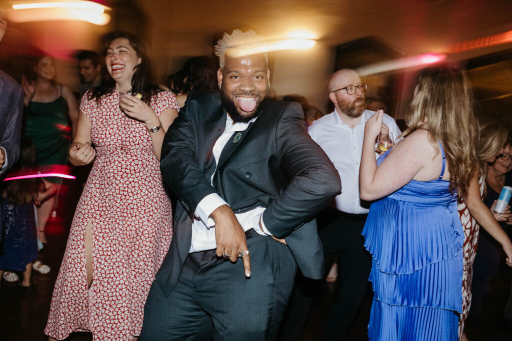 Wedding guests smiling and dancing at a reception 