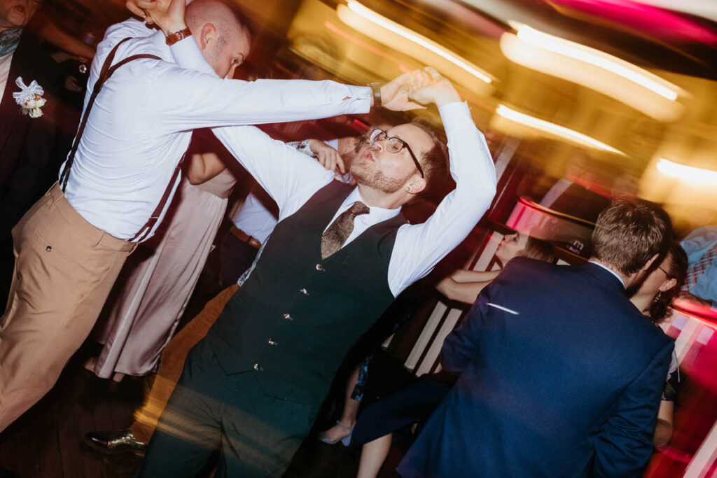 Newlyweds dancing at their wedding reception with blurred lights around them 