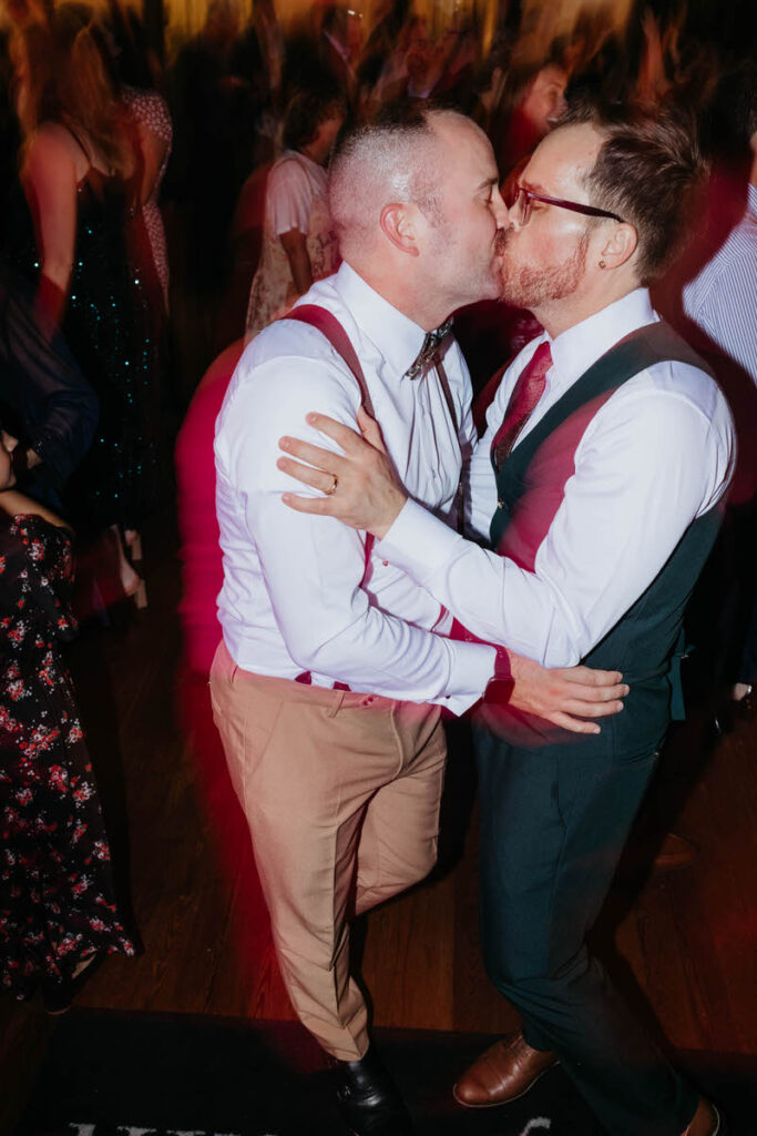 A newlywed couple kissing and dancing at their wedding reception 