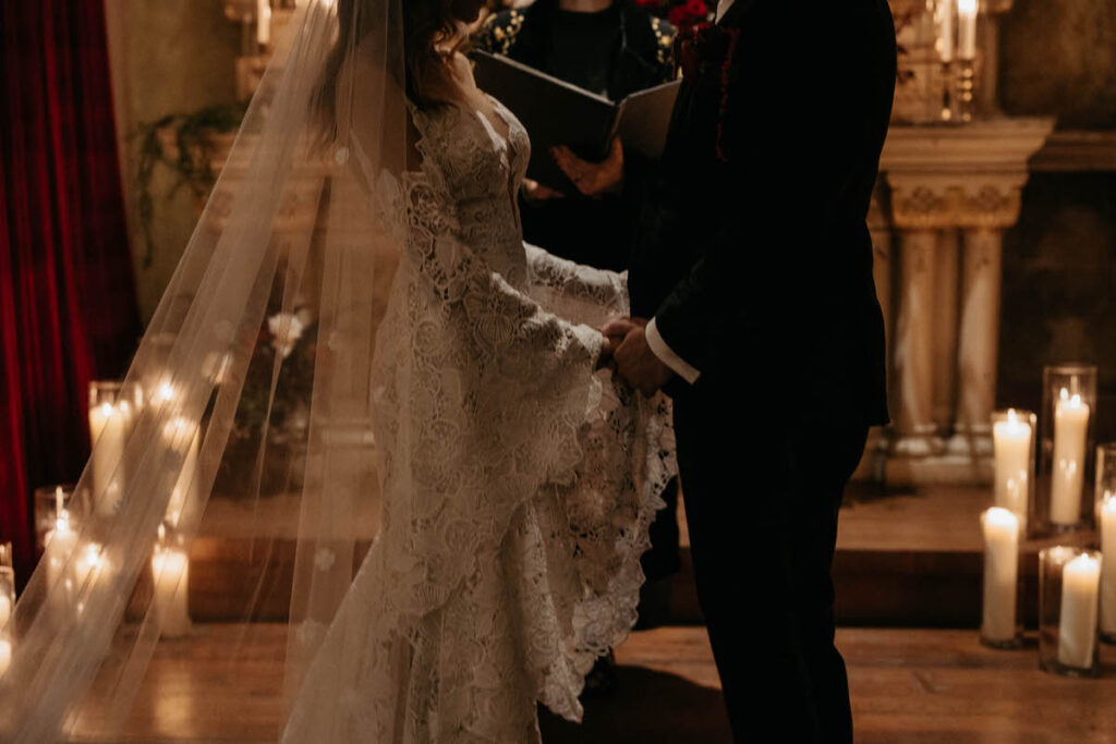A wedding couple holding hands as they say their vows