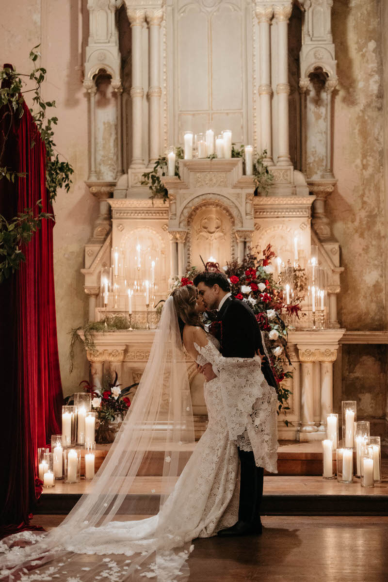 A newlywed couple during their first kiss at their wedding
