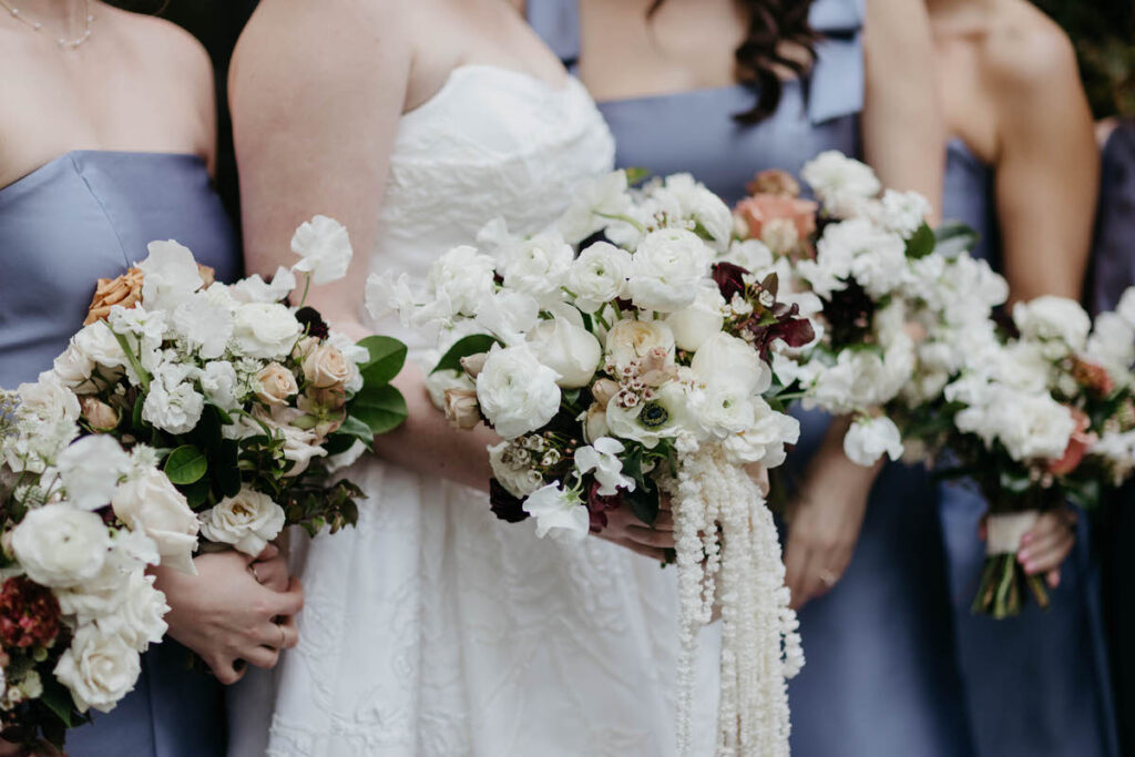 A group of people standing in a line all holding bouquets of flowers