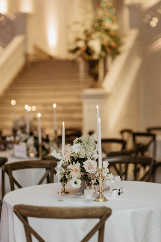 Circular tables with small floral arrangements and tall candles in the middle