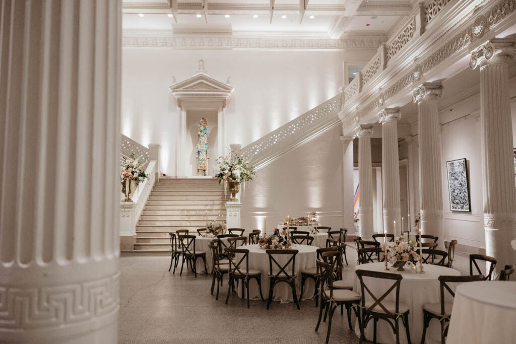 A white reception area with small, circular tables set up
