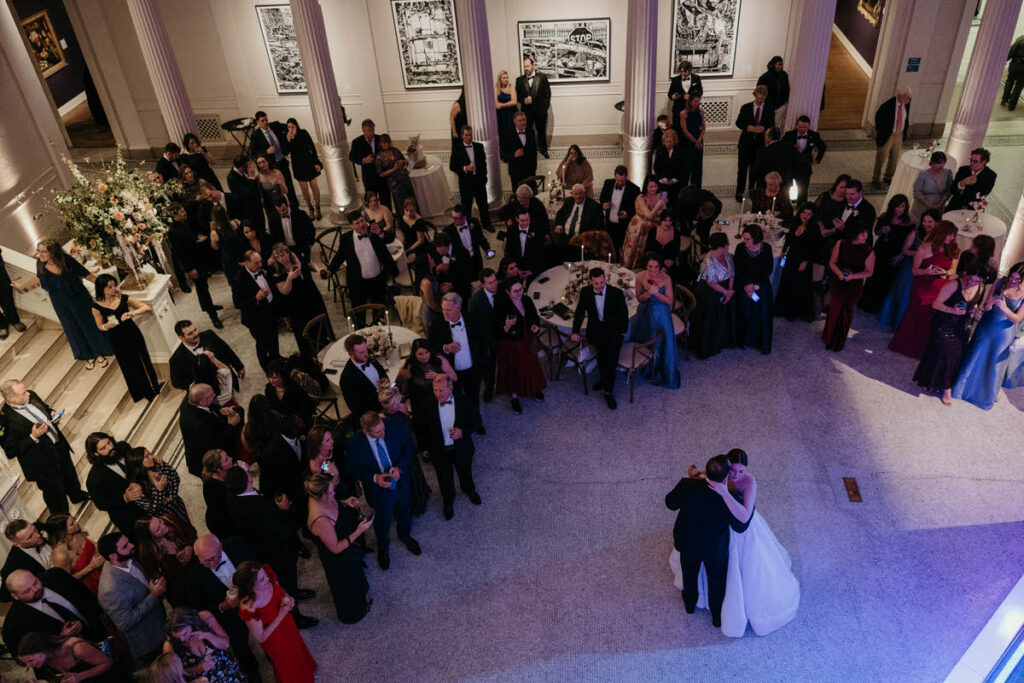 View looking down at a newlywed couple during their first dance with their wedding guests looking on