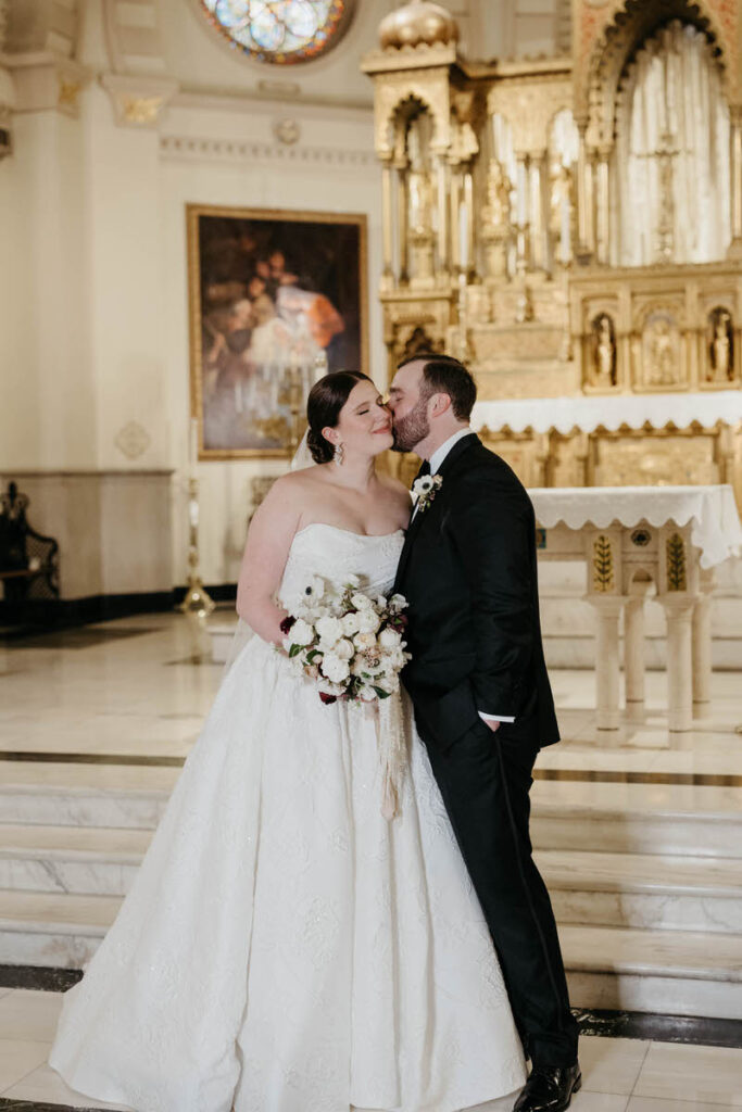 A person giving their partner a kiss on the cheek after their wedding ceremony