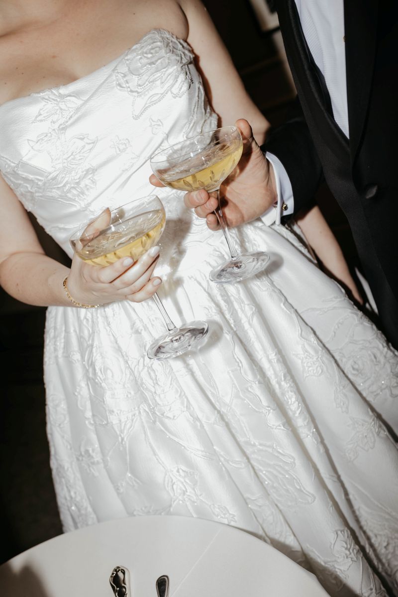 a couple holding up two champagne glasses at their new orleans museum of art wedding