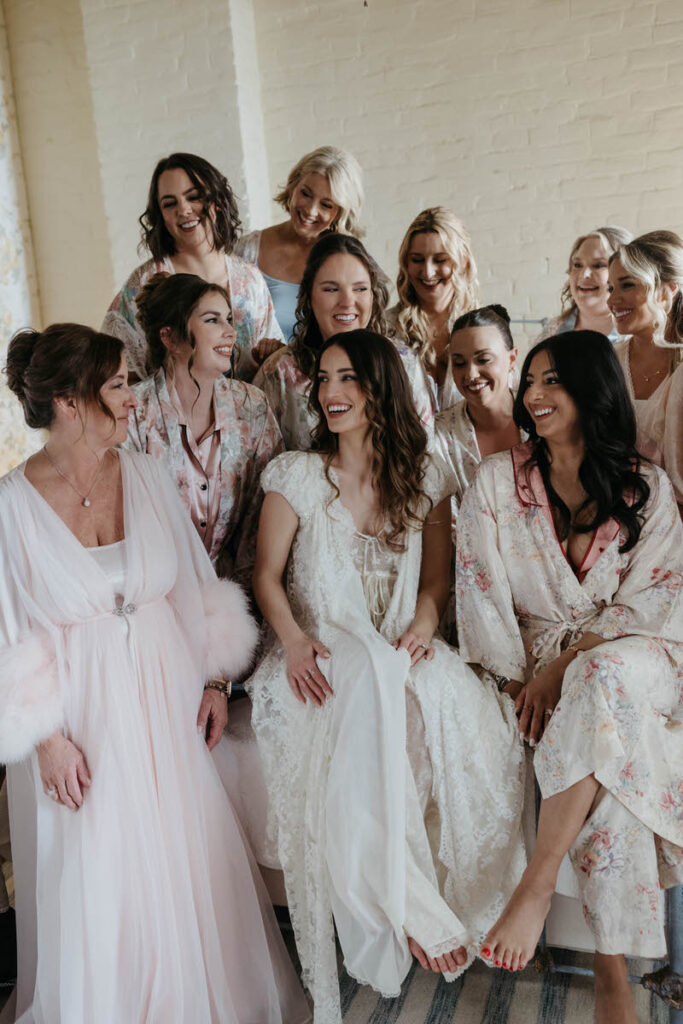 A person sitting down and smiling with their wedding party sitting around them