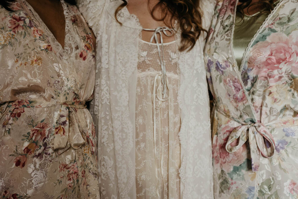 Close up view of three people with intricate lace and silk robes on