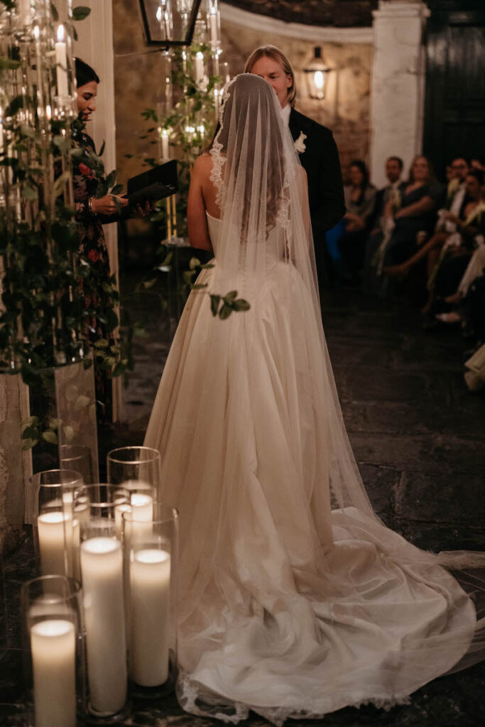 View from behind one person of a couple standing up and saying their vows