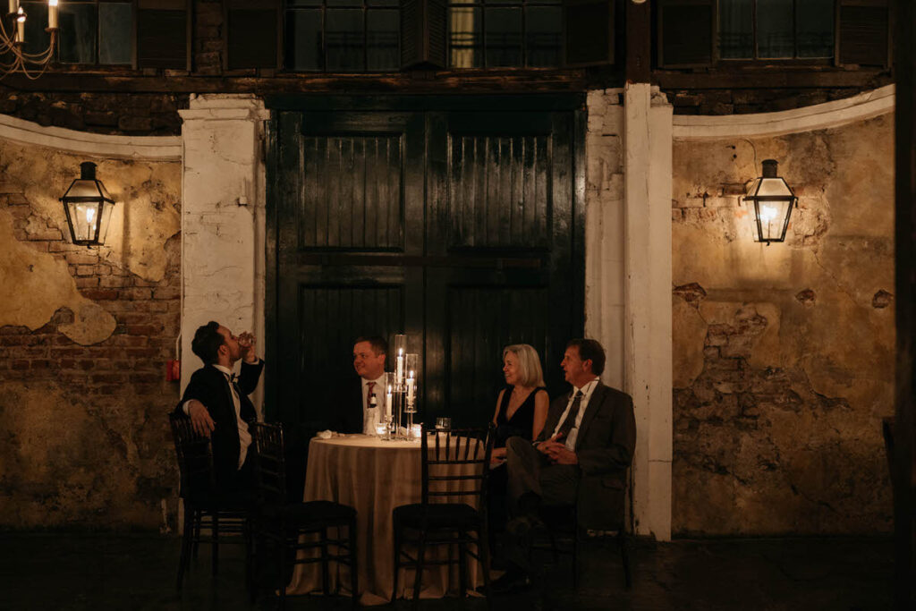 A group of people sitting around a small table in a courtyard