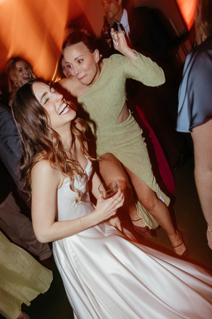 A newlywed laughing and dancing with their wedding guests
