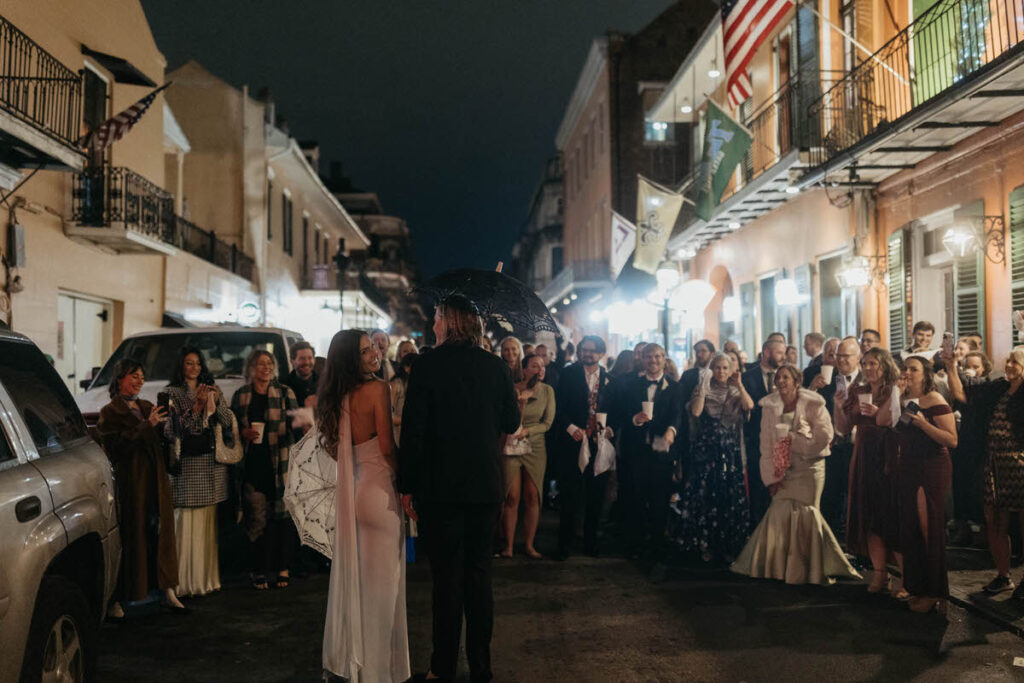 A couple walking down the streets of New Orleans celebrating with their wedding guests