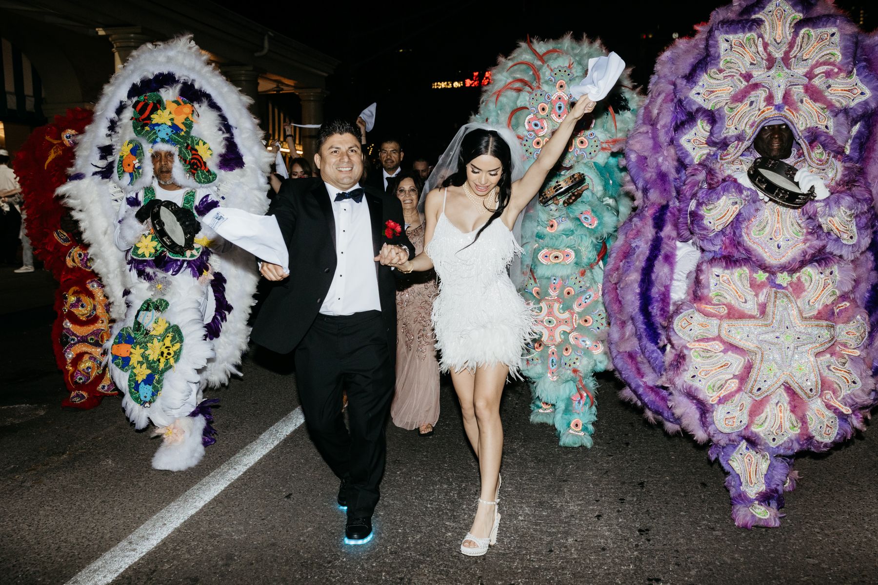 a couple walking in front of the mardi gras indians second line parade in new orleans 