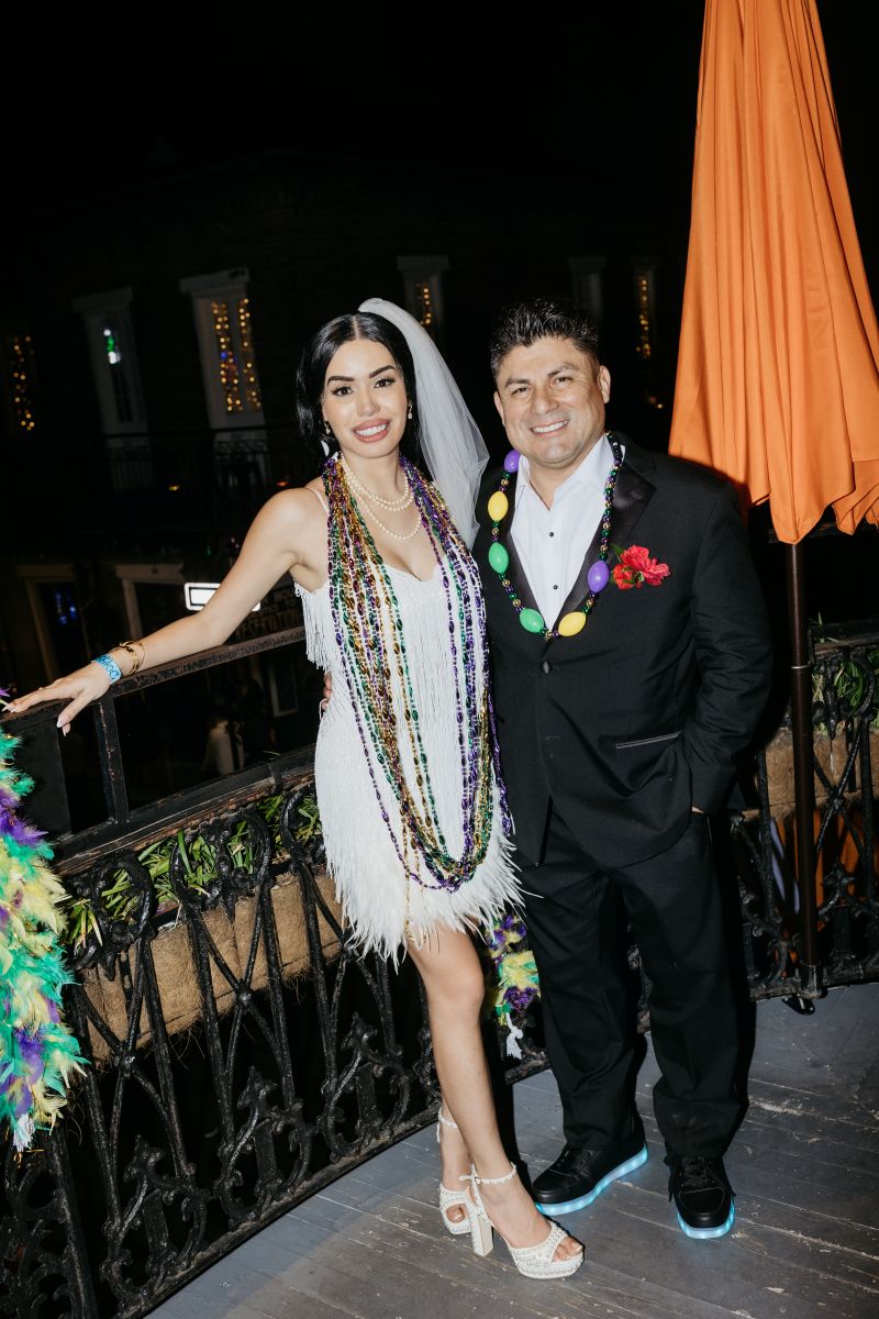 a couple standing on the balcony of cornet together celebrating their marriage 
