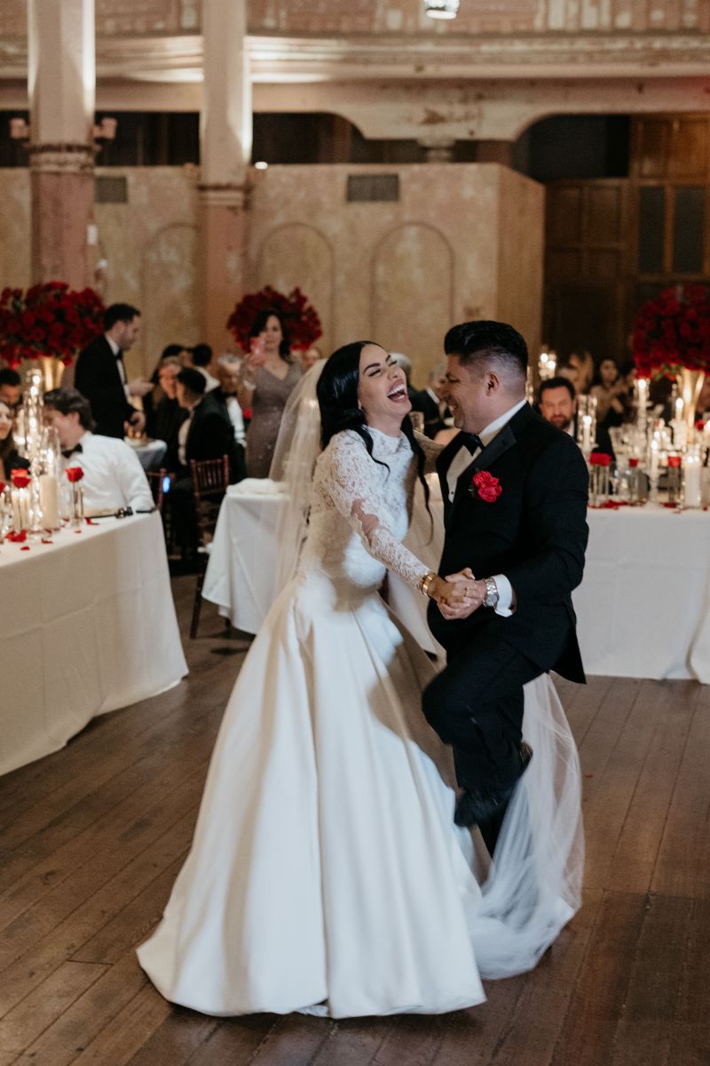 a couple laughing and dancing together at their wedding reception 