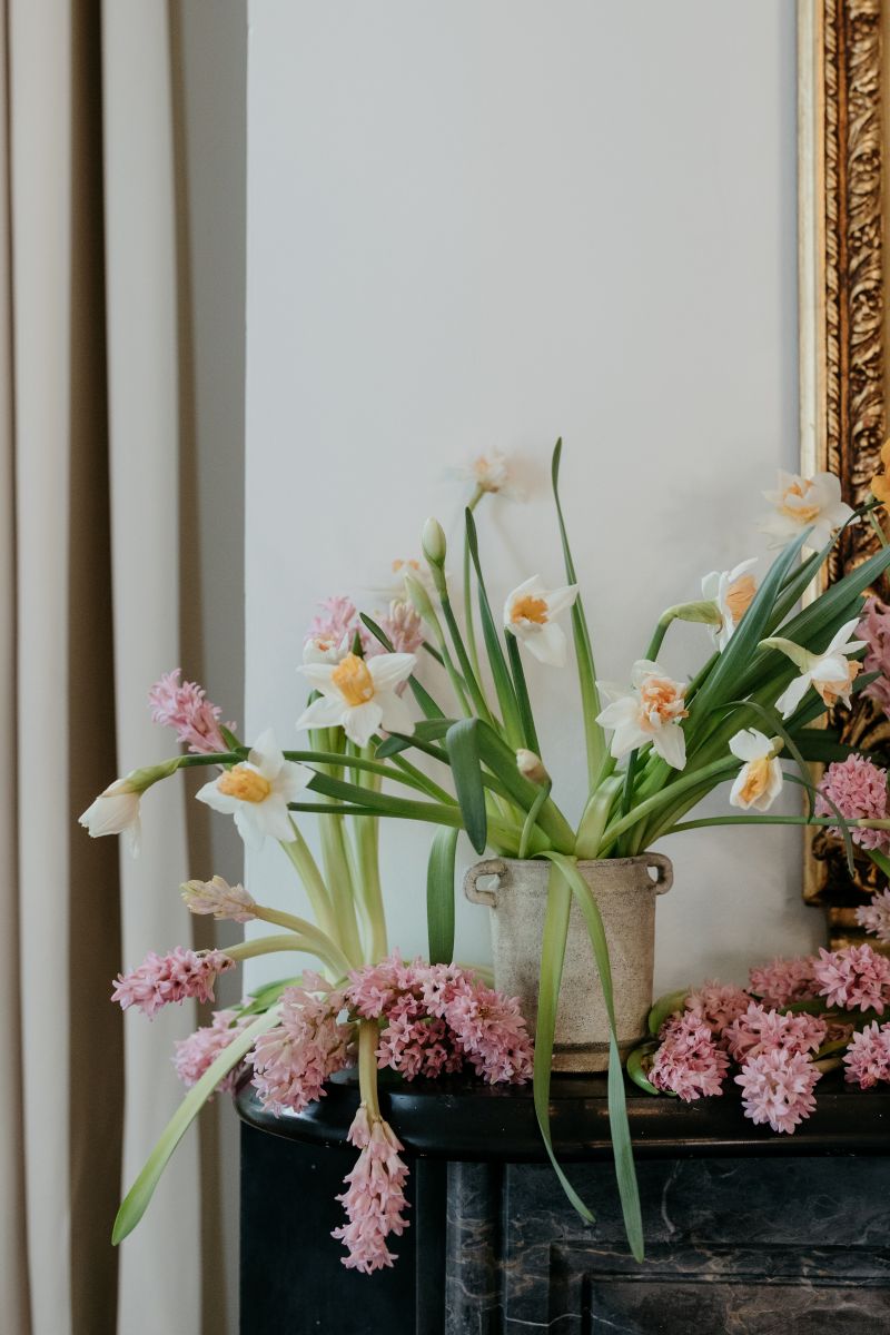 beautiful flowers on top of the black fireplace inside of derbes mansion