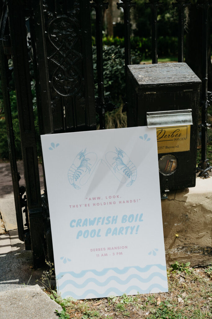 A large sign for a crawfish boil and pool party 