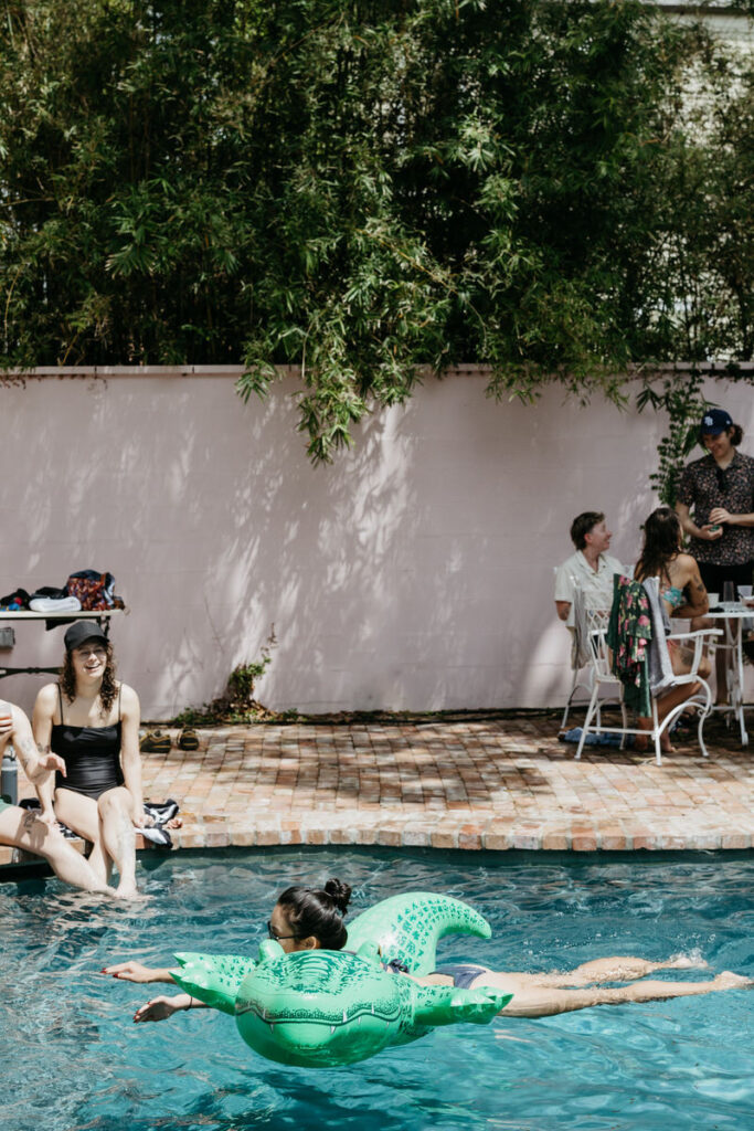 A person floating on an alligator float in a pool 