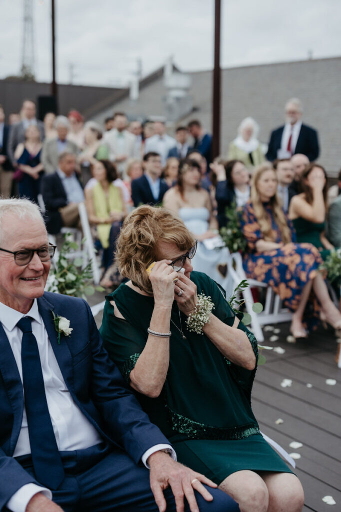 A wedding guest wiping tears during a wedding ceremony 
