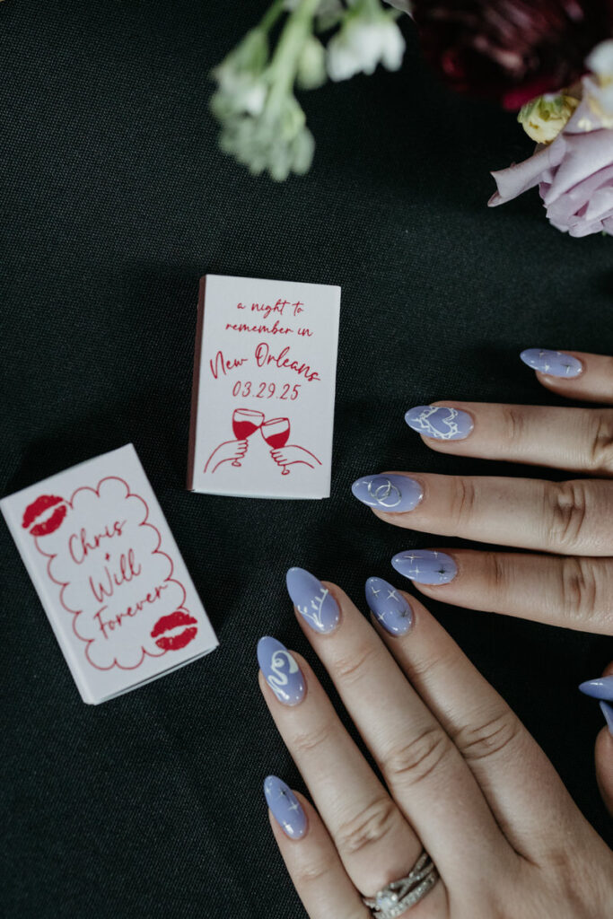 Someone showing off intricate nails with small booklets in front of them 