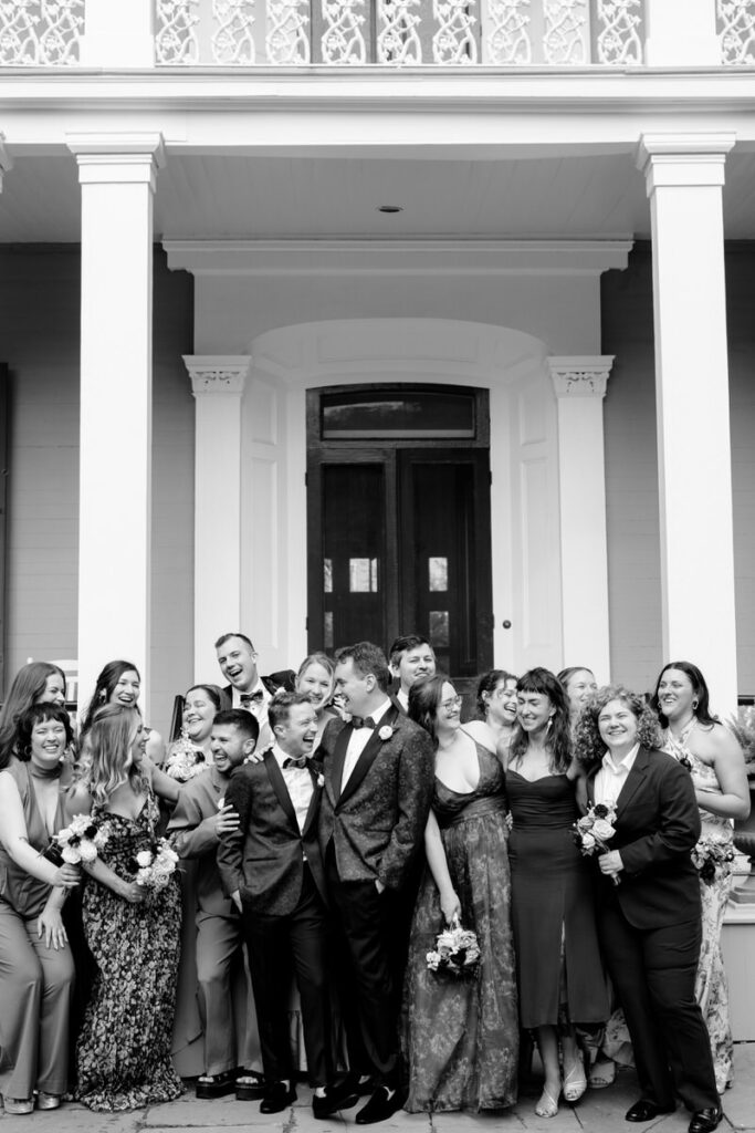 Newlyweds smiling and laughing with wedding guests around them 