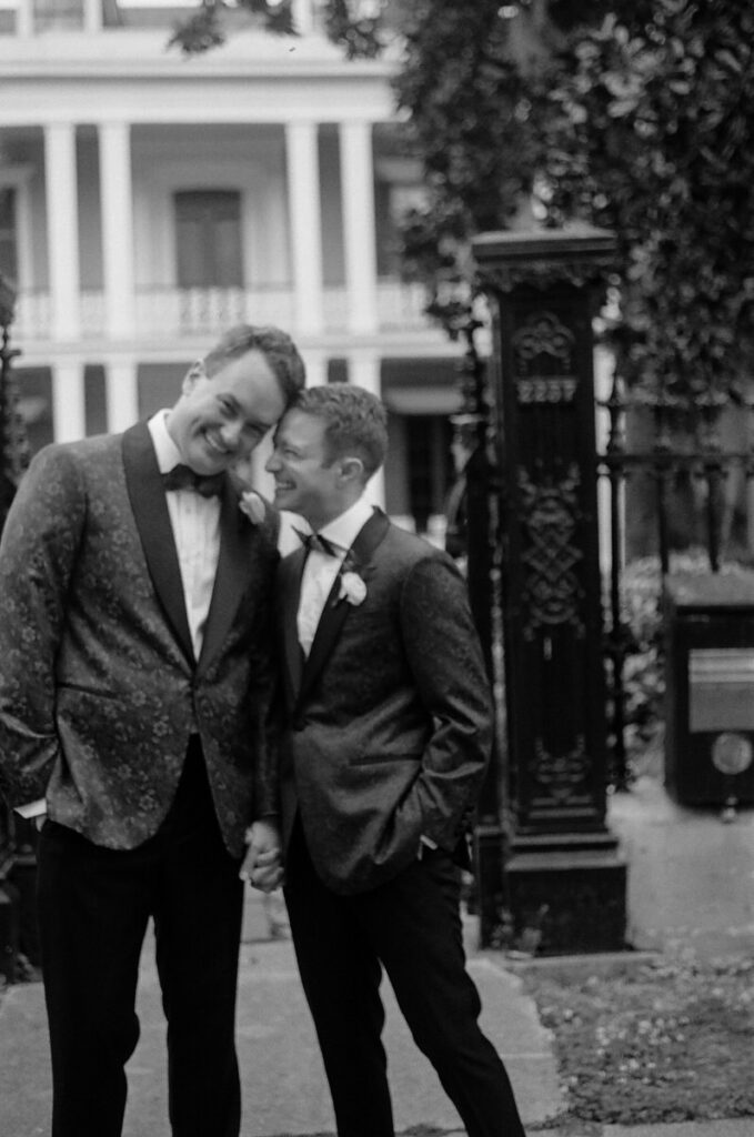 Newlyweds holding hands and smiling with their foreheads together 