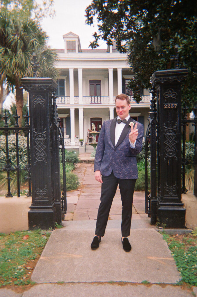 A person in a suit holding up a peace sign 