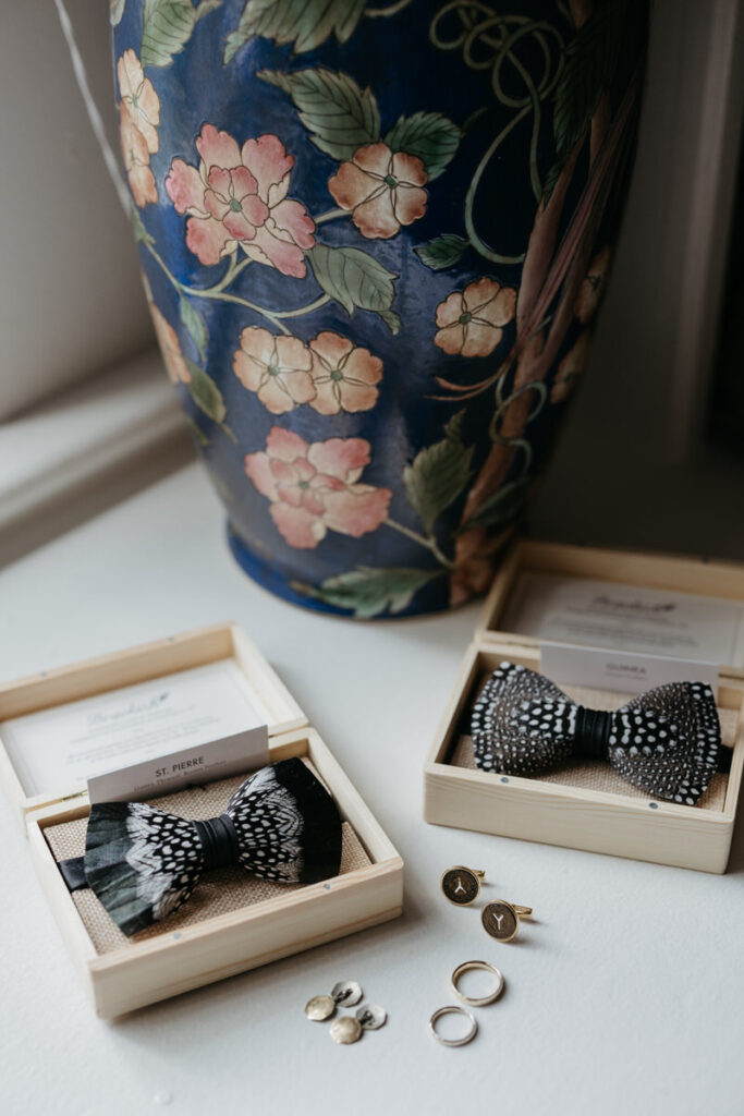 Bowties, cufflinks, and small pins laid out together 