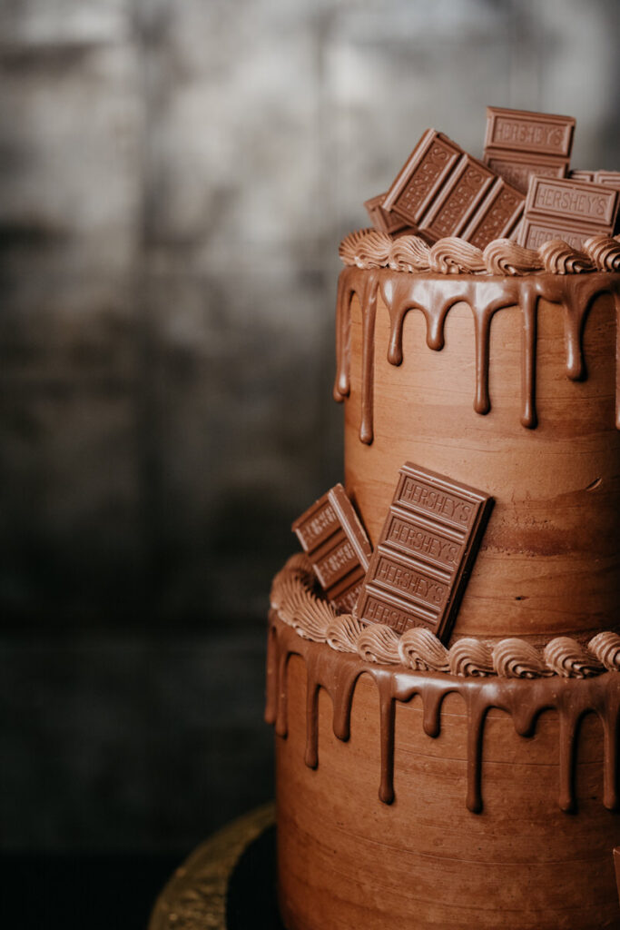 A two tiered chocolate wedding cake with Hersey's bars on it
