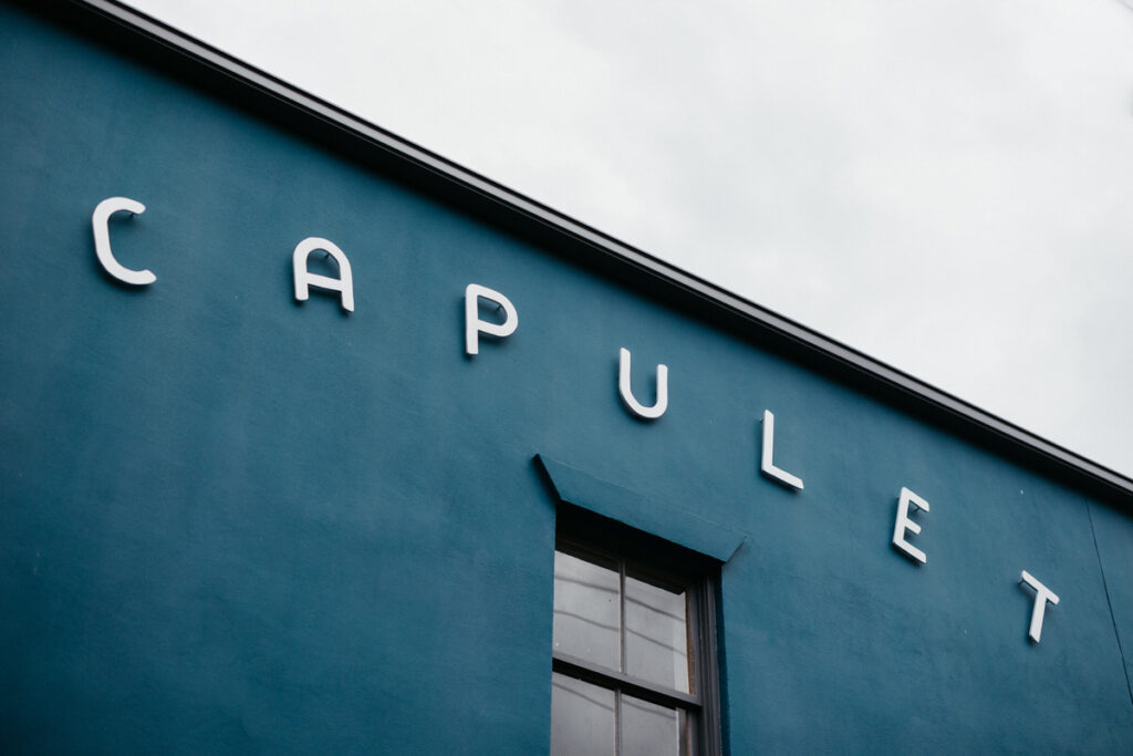 A blue building with white letters that read "Capulet" 