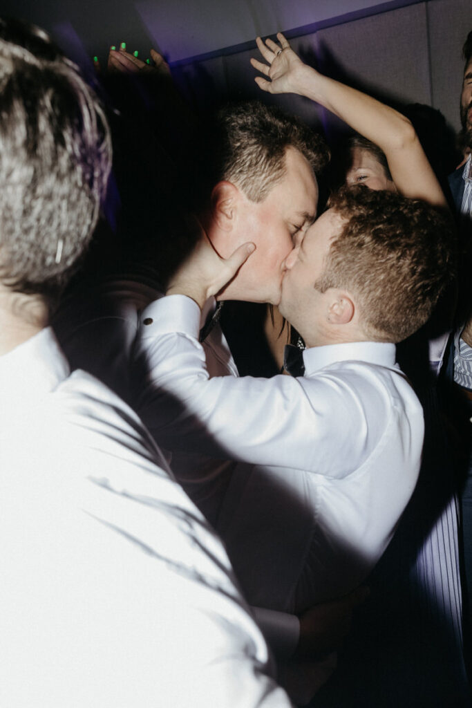 Newlyweds kissing on the dance floor at their wedding reception 