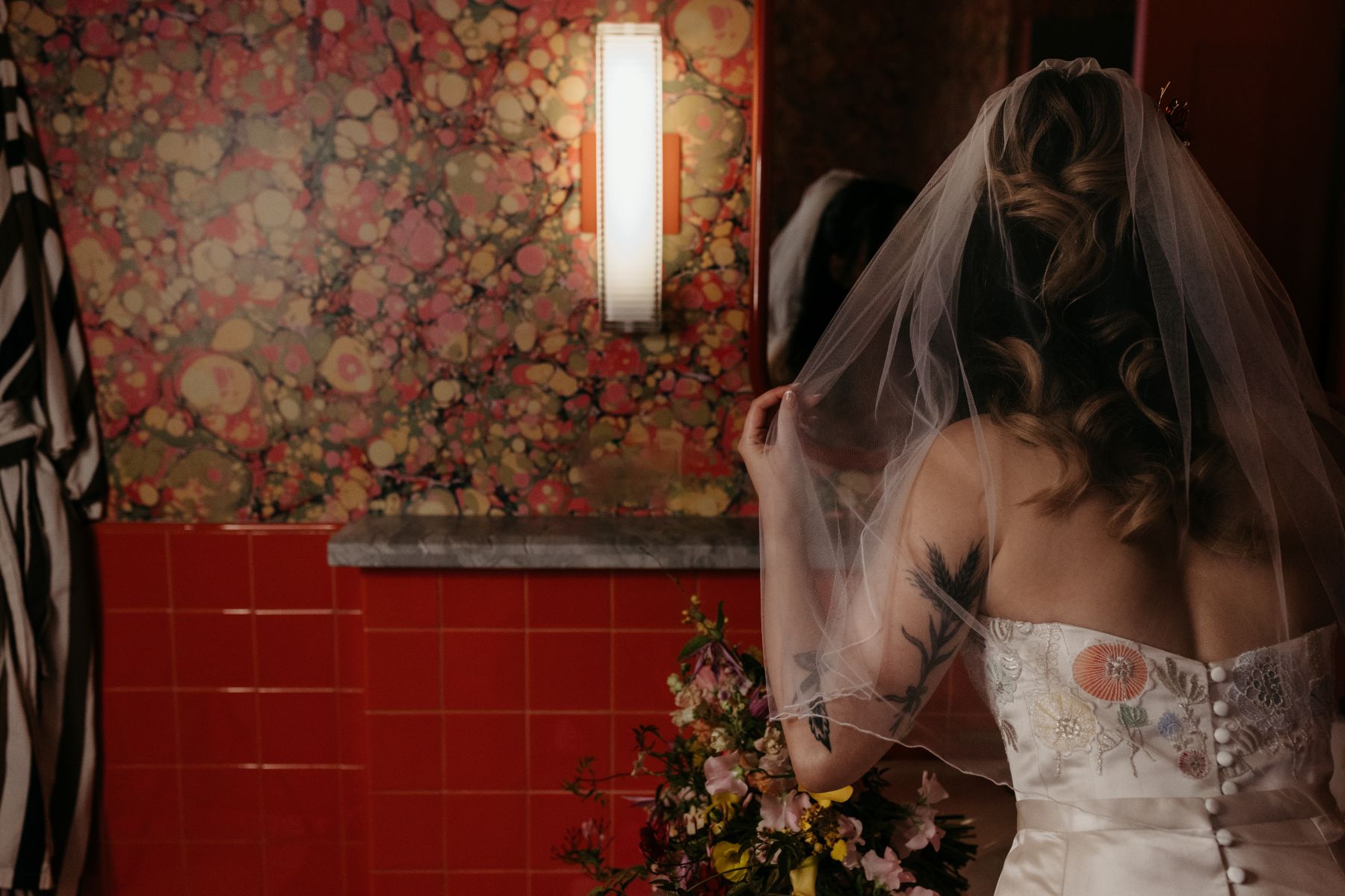 a woman in a bathroom getting ready for her wedding and looking the in the mirror