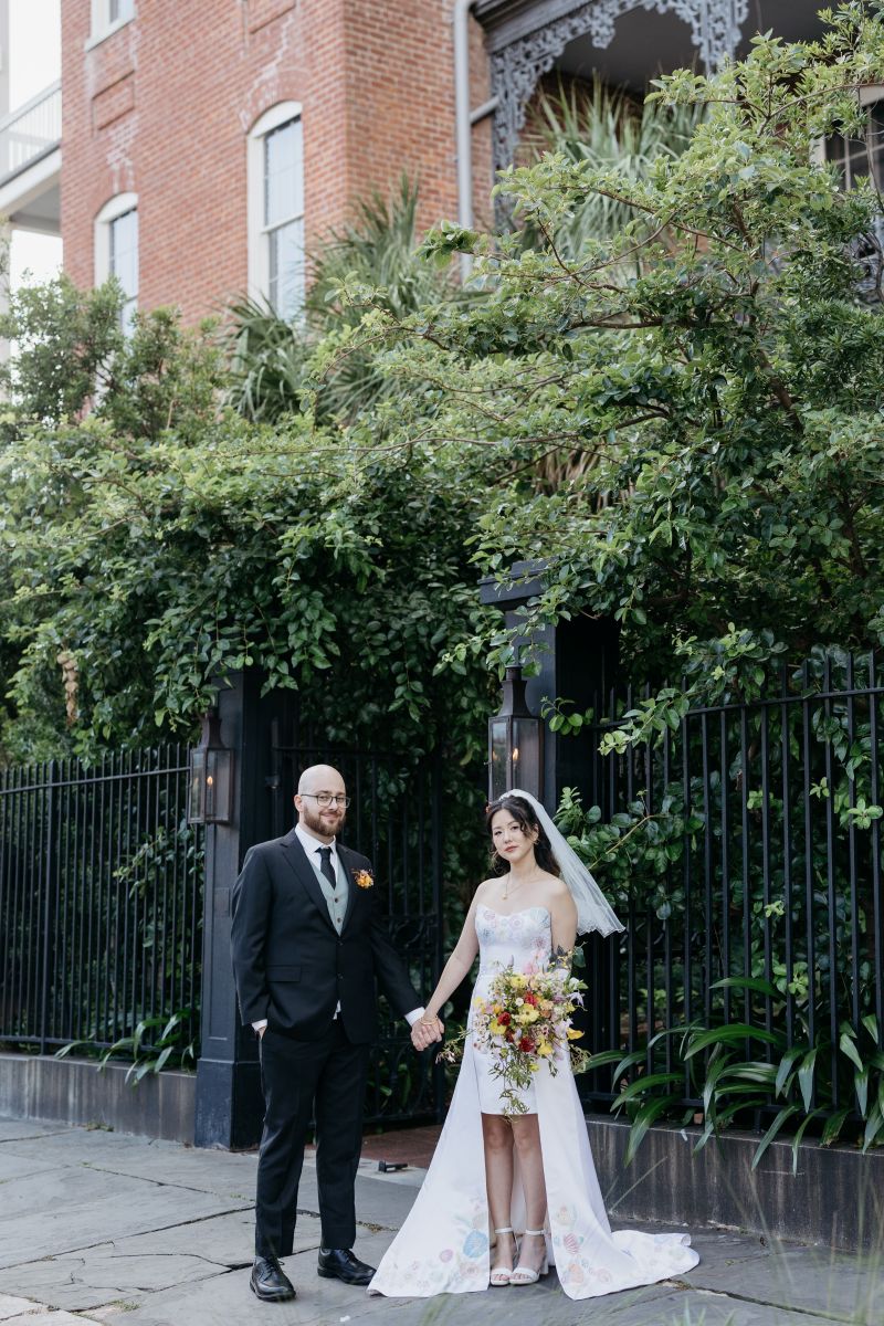a man and woman holding hands in front of hotel saint vincent in new orleans before their wedding