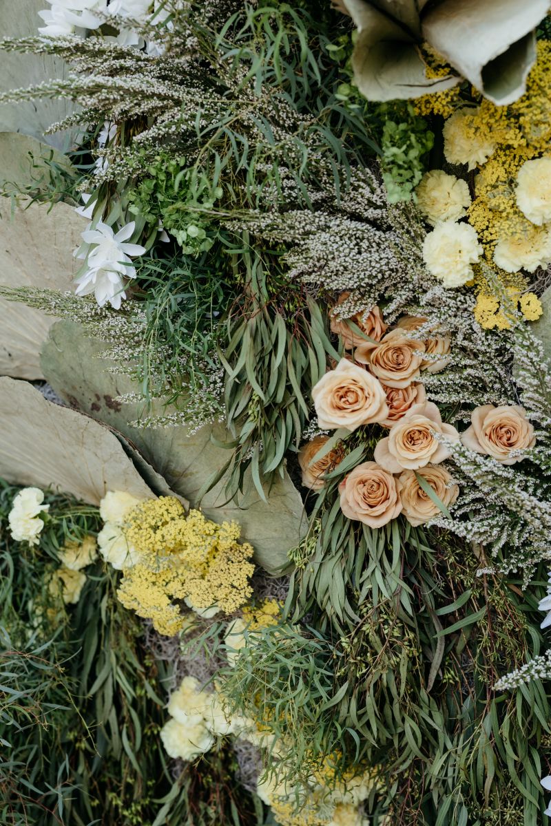 a colorful floral arrangement consisting of roses and dried plants and flowers